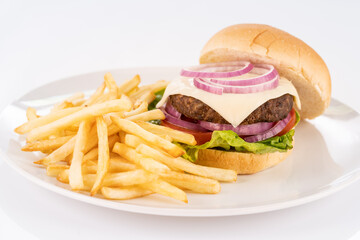Cheese beef burger with shoestring fries on a white plate