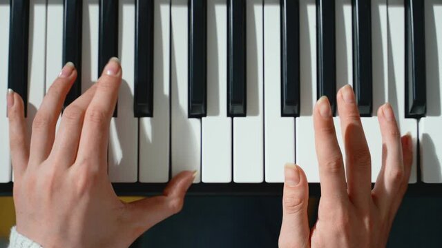 Girl playing piano. Close-up view.