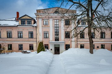 Path leads through the snowy park to the manor. Cere Manor, Latvia. The Cēre primary school is located in the manor house.