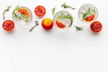 Red orange lemonade in glasses with ice and rosemary