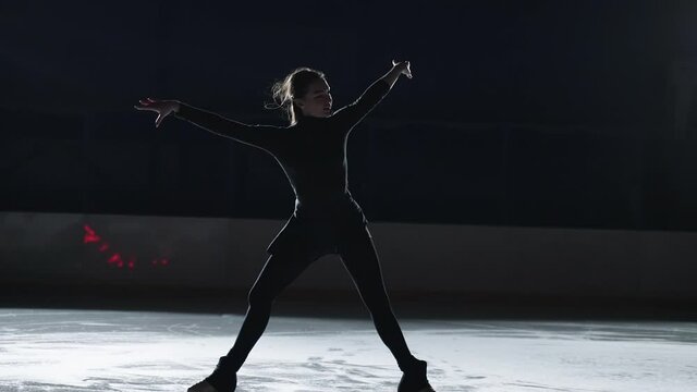 Professional female ice figure skater practicing spin on indoor skating rink Shot on 120 FPS Slow motion