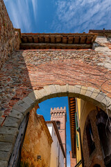 The bell tower of the Church of Sant'Andrea framed by the arch of the Porticciola or Porta a Lucca,...