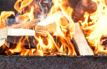 Fire. Firewood is burning in the grill. Orange firelight, sparks flying. Fire background.
