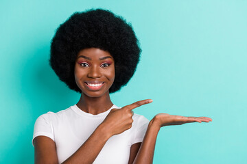 Photo of cool short hairdo young lady point hold empty space wear white t-shirt isolated on cyan color background