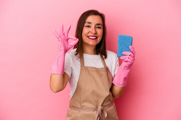 Middle age caucasian woman cleaning home isolated on pink background cheerful and confident showing ok gesture.