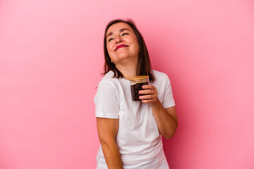 Middle age caucasian woman holding a coffee jar isolated on pink background dreaming of achieving goals and purposes
