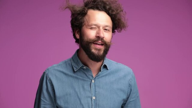 casual man winking at the camera, being very playful and flirtatious then blowing a kiss