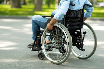 Cropped view of young black disabled man in wheelchair enjoying summer at green park, closeup
