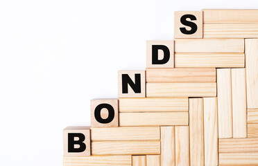 On a light background, wooden blocks and cubes with the text BONDS
