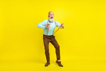 Naklejka premium Full length body size photo gentleman wearing shirt suspenders laughing dancing at party isolated vibrant yellow color background