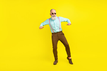 Fototapeta na wymiar Full length body size photo elder man wearing suspenders sunglass chilling on weekend isolated bright yellow color background