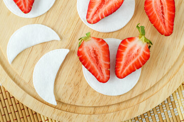 Fresh strawberry and cotton eye patches for preparing homemade face or eye mask. Natural beauty treatment and spa recipe. Top view.