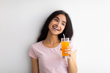 Summer detox and healthy eating concept. Smiling Indian woman with glass of fresh orange juice...