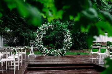 Round arch for a wedding ceremony of green branches and flowers in the garden