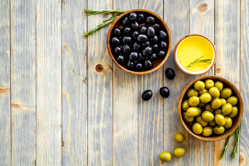 Top view of green and black olives in bowls with oil
