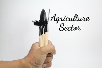 hand holding agricultural tools with the word Agriculture Sector