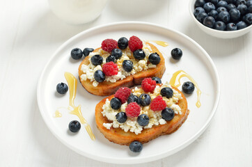 Sandwiches with curd cheese, blueberries, raspberries and honey
