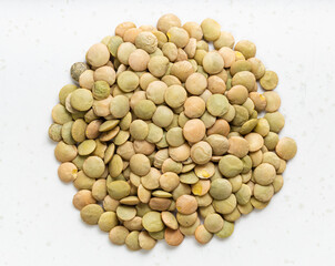 pile of raw large green lentils close up on gray