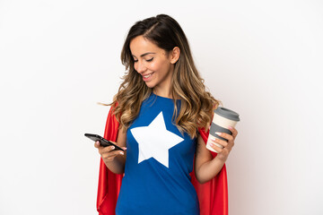 Naklejka premium Super Hero woman over isolated white background holding coffee to take away and a mobile