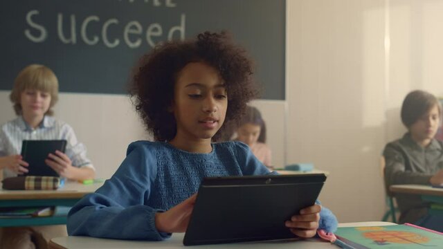 Student holding digital tablet in classroom. Schoolgirl using tablet computer 