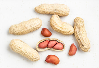 peeled and whole peanuts close up on gray