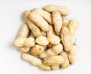 top view of pile of whole peanuts on gray