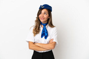 Airplane stewardess over isolated white background looking up while smiling