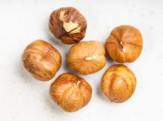 several shelled hazelnuts close up on gray