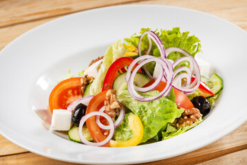 Greek salad with feta cheese on the wooden background