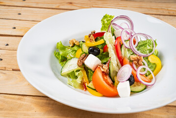 Greek salad with feta cheese on the wooden background