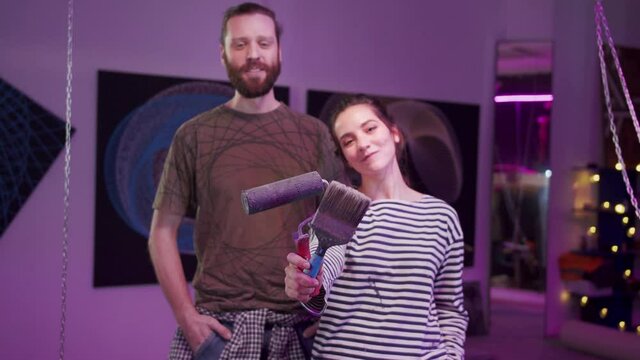 Two painters are standing with painting tools 