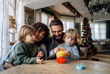 Fototapeta premium Happy family having fun time at home, parents playing with children.
