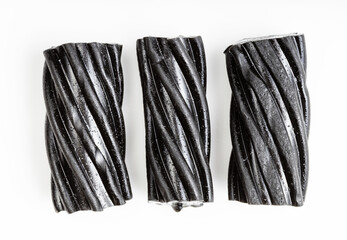 few coiled black licorice candies on white