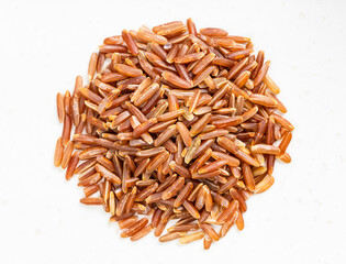pile of raw red rice close up on gray