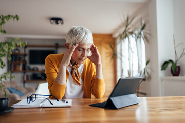 Senior woman, brainstorming during work hours, at home.