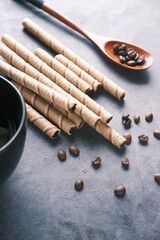 wafer roll chocolate , coffee beans and coffee mug on table ,