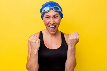 Young australian swimmer woman isolated on yellow background cheering carefree and excited. Victory concept.