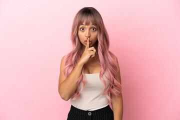 Young mixed race woman with pink hair isolated on pink background showing a sign of silence gesture...