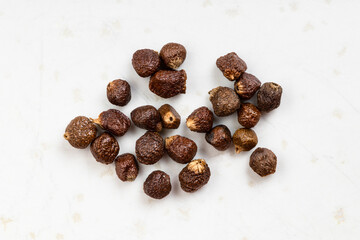 several grains of paradise pepper close up on gray
