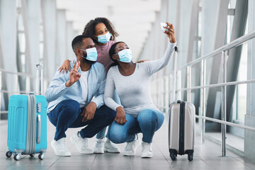 Happy black family traveling with kid, taking selfie in airport