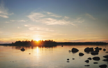 Sun sits down behid island. Beautiful sunset rays, reflecting in water.  Clean nordic nature, Baltic sea, gulf of Finland