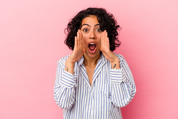 Young curly latin woman isolated on pink background surprised and shocked.