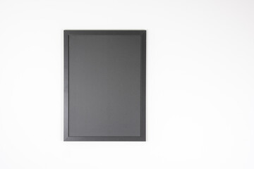 Small blackboard or black picture frame on a white wall