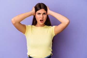 Young caucasian woman isolated on purple background screaming with rage.