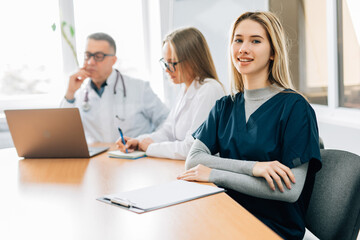 Small group of doctors in a meeting discusing a medical history in hospital