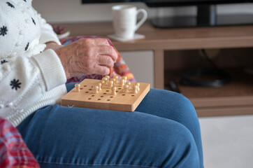 Close up image of a senior woman's hands playing a game 