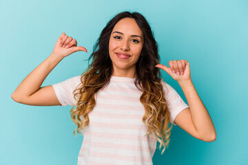Young mexican woman isolated on blue background feels proud and self confident, example to follow.