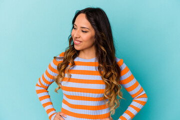 Young mexican woman isolated on blue background dreaming of achieving goals and purposes