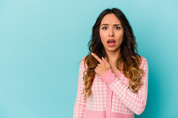 Fototapeta premium Young mexican woman isolated on blue background pointing to the side