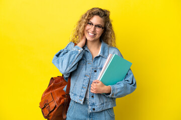 Young student caucasian woman isolated on yellow background laughing